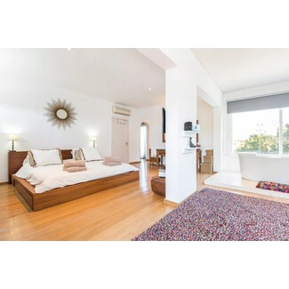 Bohemian style bedroom with canopy bed and patterned rug