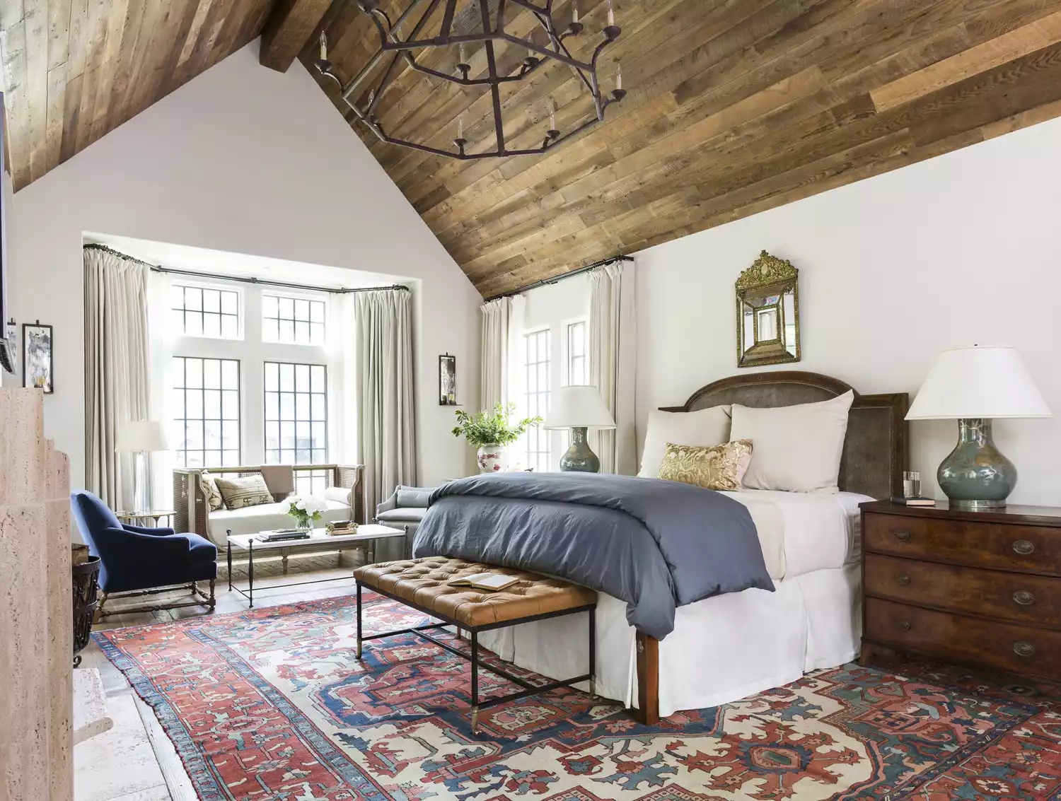 Light-filled bedroom with canopy bed and cozy seating area