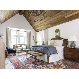 Light-filled bedroom with canopy bed and cozy seating area