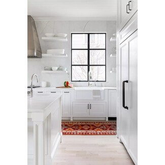 White kitchen with red patterned runner and colorful dishware