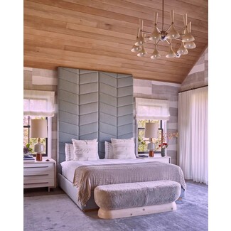 Eclectic bedroom with statement lighting and patterned headboard
