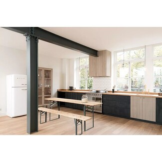 Spacious English loft kitchen with black-and-white theme and dark green beams