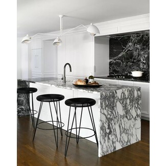 Glamorous black and white marble kitchen with contemporary lighting and warm hardwood flooring