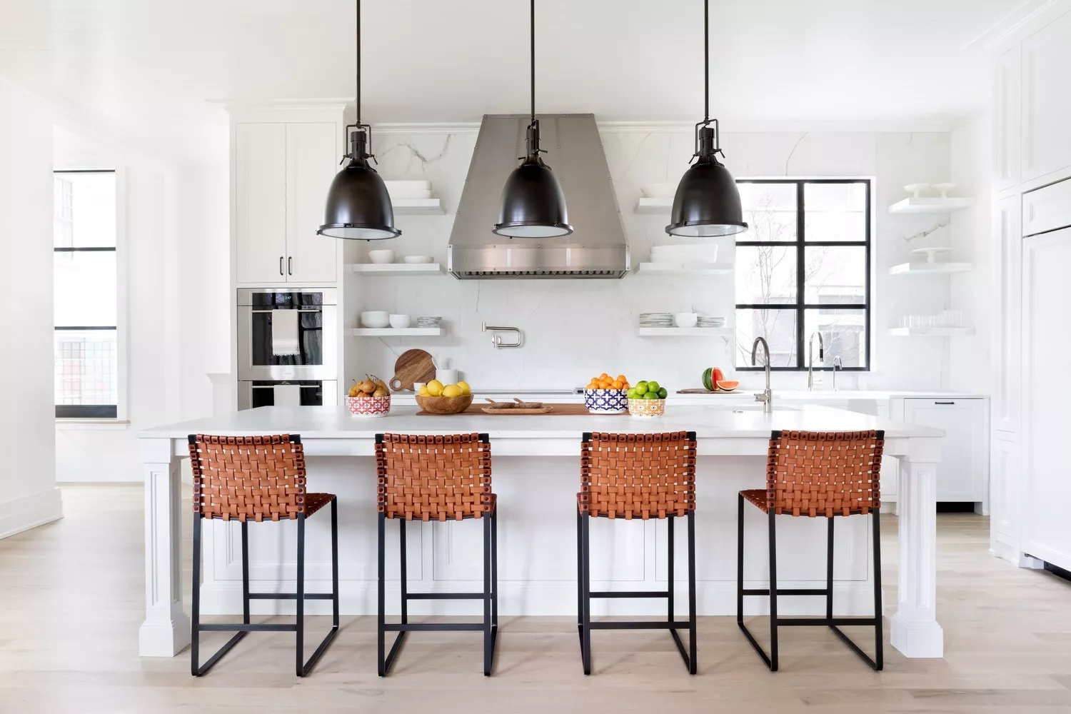 Modern black and white kitchen with cognac leather bar stools and mix of textures and materials