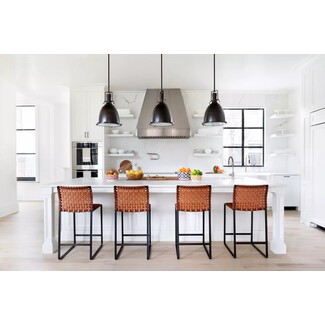 Modern black and white kitchen with cognac leather bar stools and mix of textures and materials