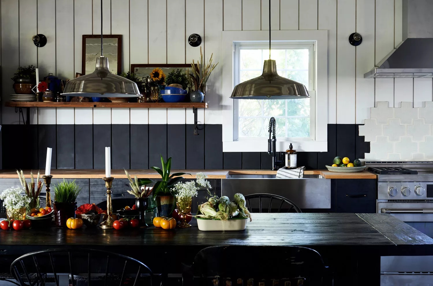 Modern black-and-white kitchen with black farmhouse table and chairs, black-and-white shiplap walls, and colorful kitchen essentials