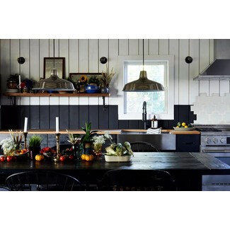 Modern black-and-white kitchen with black farmhouse table and chairs, black-and-white shiplap walls, and colorful kitchen essentials