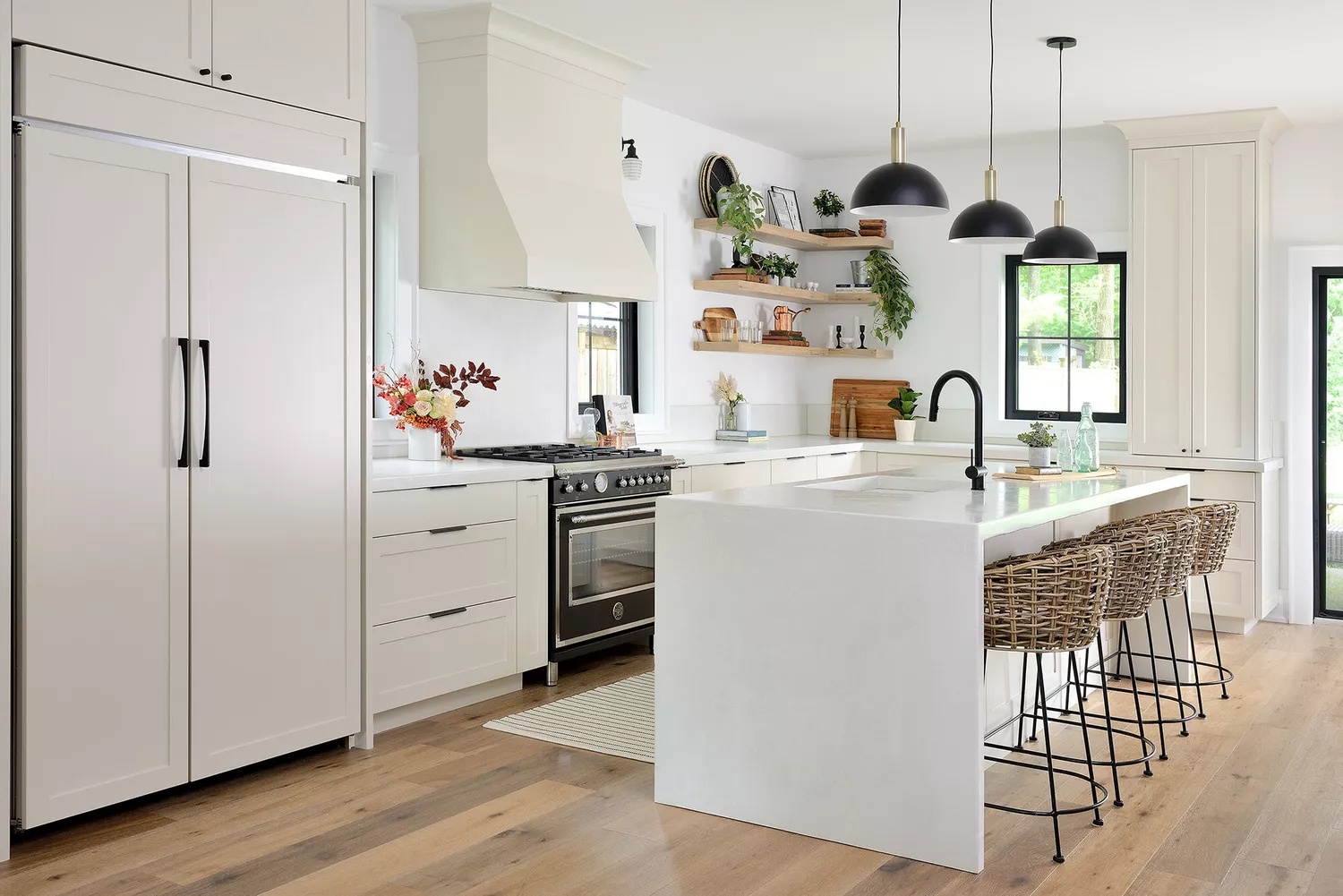 Modern family kitchen with subtle black accents and pale hardwood flooring