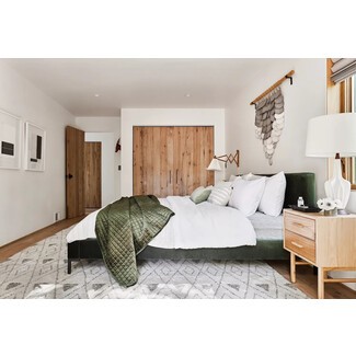 Mountain house guest room with rustic decor and wooden ceiling