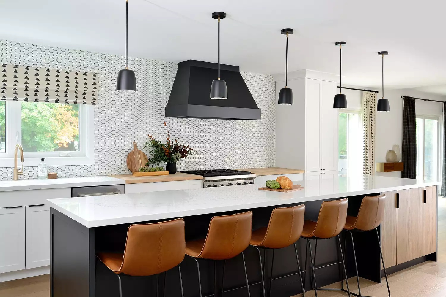 https://visualhunt.com/photos/23/open-plan-black-white-kitchen-cognac-leather-bar-stools-tiled-backsplash-black-island-range-hood.jpeg