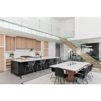 Sprawling open-plan kitchen and dining room with black-and-white palette and wood cabinetry and accents