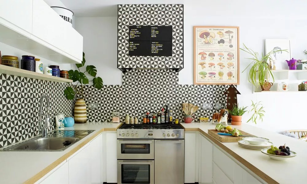 Open U-shaped kitchen with geometric black-and-white tile backsplash and accent colors through textiles or small appliances