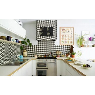 Open U-shaped kitchen with geometric black-and-white tile backsplash and accent colors through textiles or small appliances