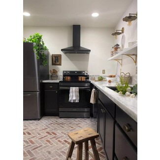 Renovated black-and-white kitchen with brick flooring and ample recessed lighting