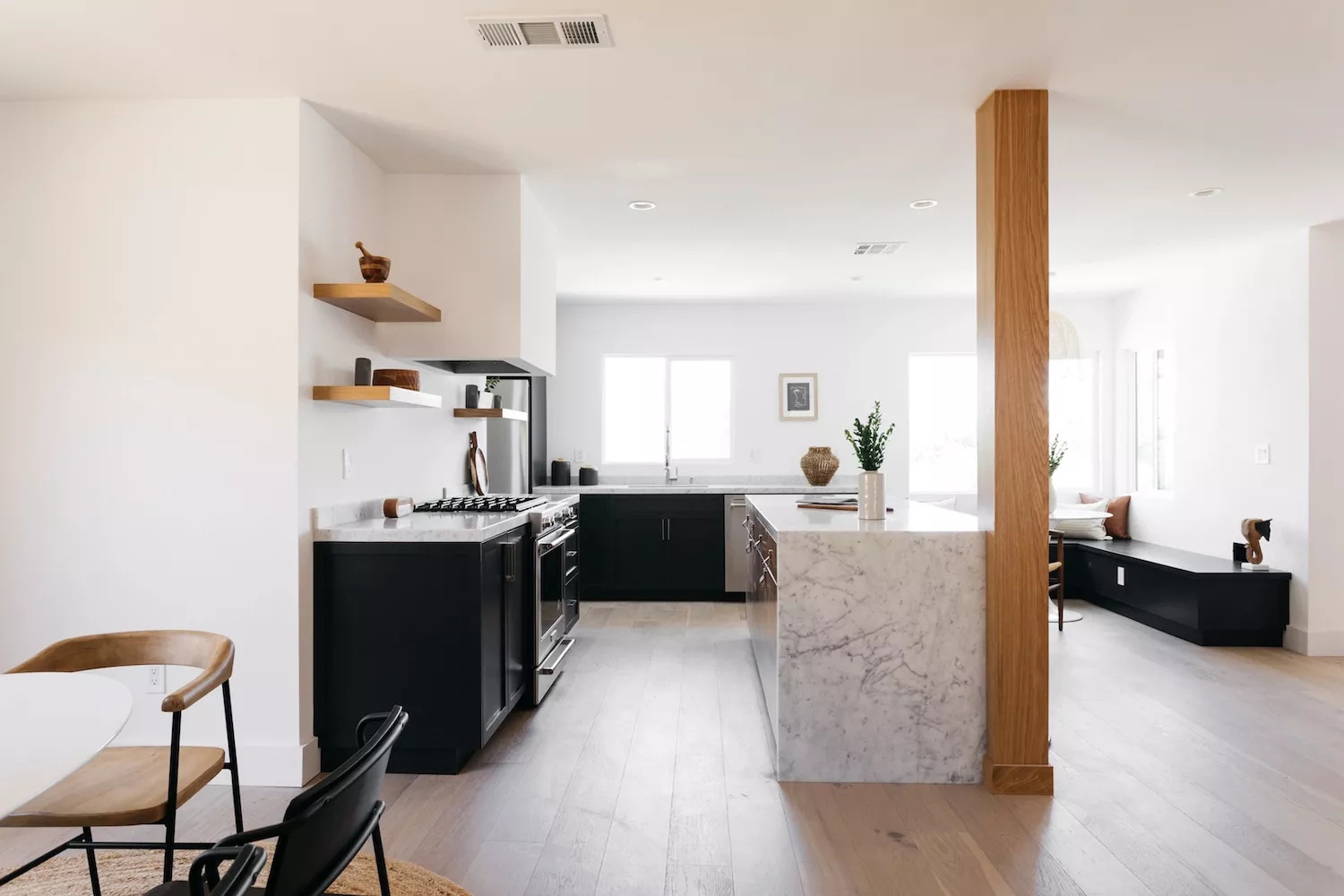 Black-and-white Southern California kitchen with light and airy feel and painted black lower cabinets