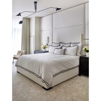 Spacious master bedroom with sitting area and modern lighting