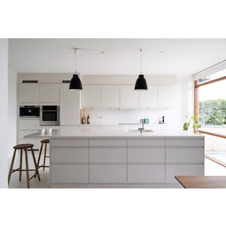 Streamlined Scandinavian-style kitchen with minimalist white cabinetry, bar seating area, and ample under-island storage