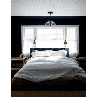 Stylish bedroom with patterned wallpaper and modern lighting