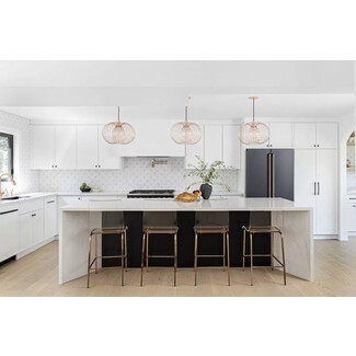 Black and white kitchen with warm metal accents and indoor plants
