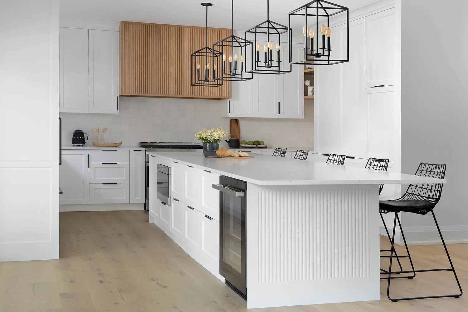 Mostly white and wood kitchen with airy black accents and warm flame bulbs