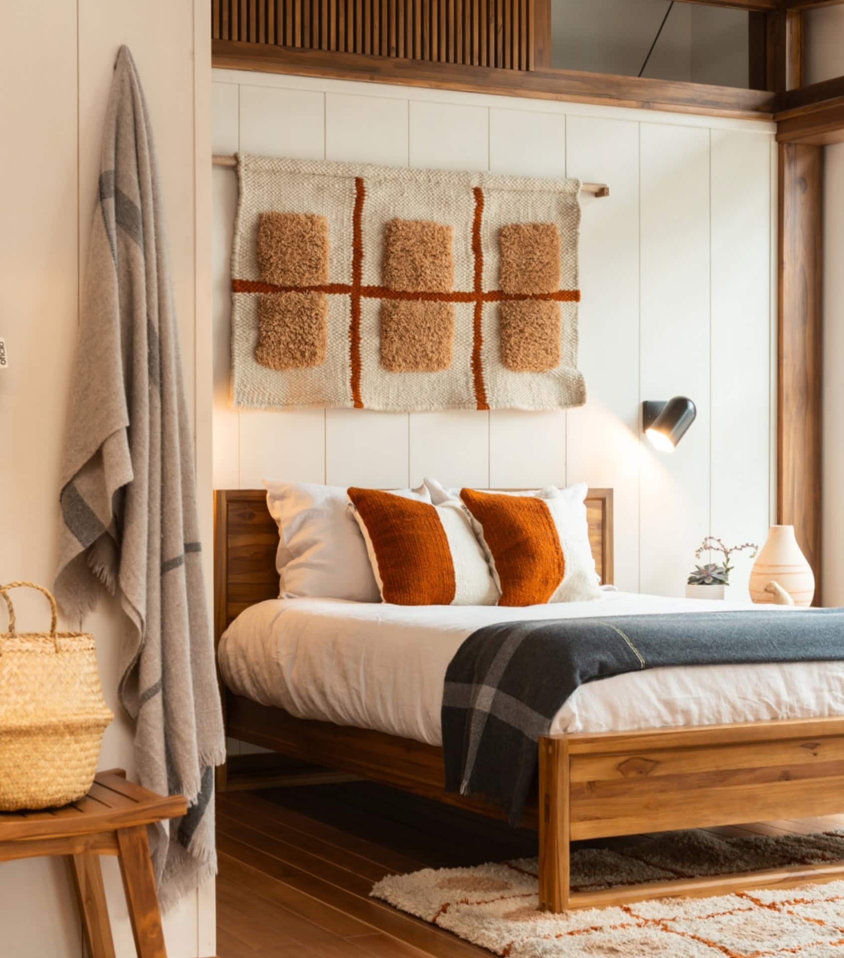 Platform Bed in Walnut Brown with Rust Accent Pillows and Tapestry