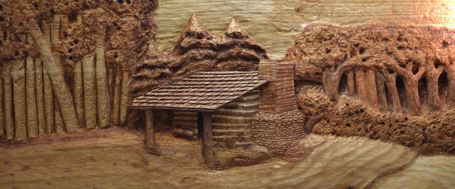 Relief Carving of a Rustic Log Cabin with Shingled Roof