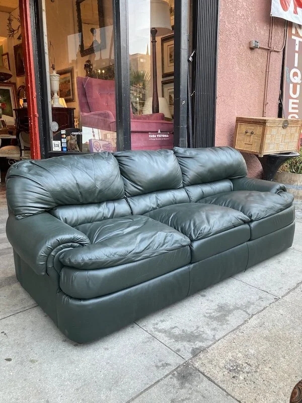 Sofa with overstuffed cushions and forest green leather