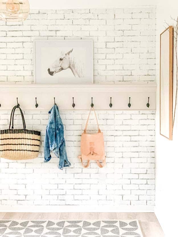 Coat Rack on Whitewashed Brick Wall with Eight Black Mudroom Hooks