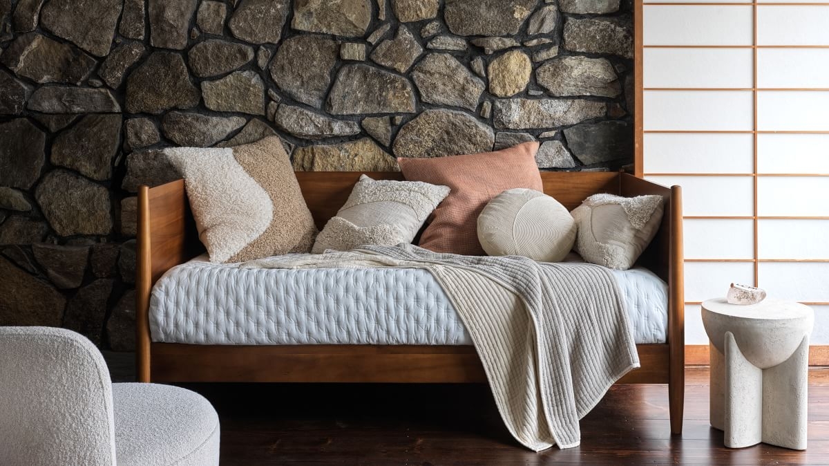 Daybed Featuring Acorn Finish Against a Natural Stone Wall