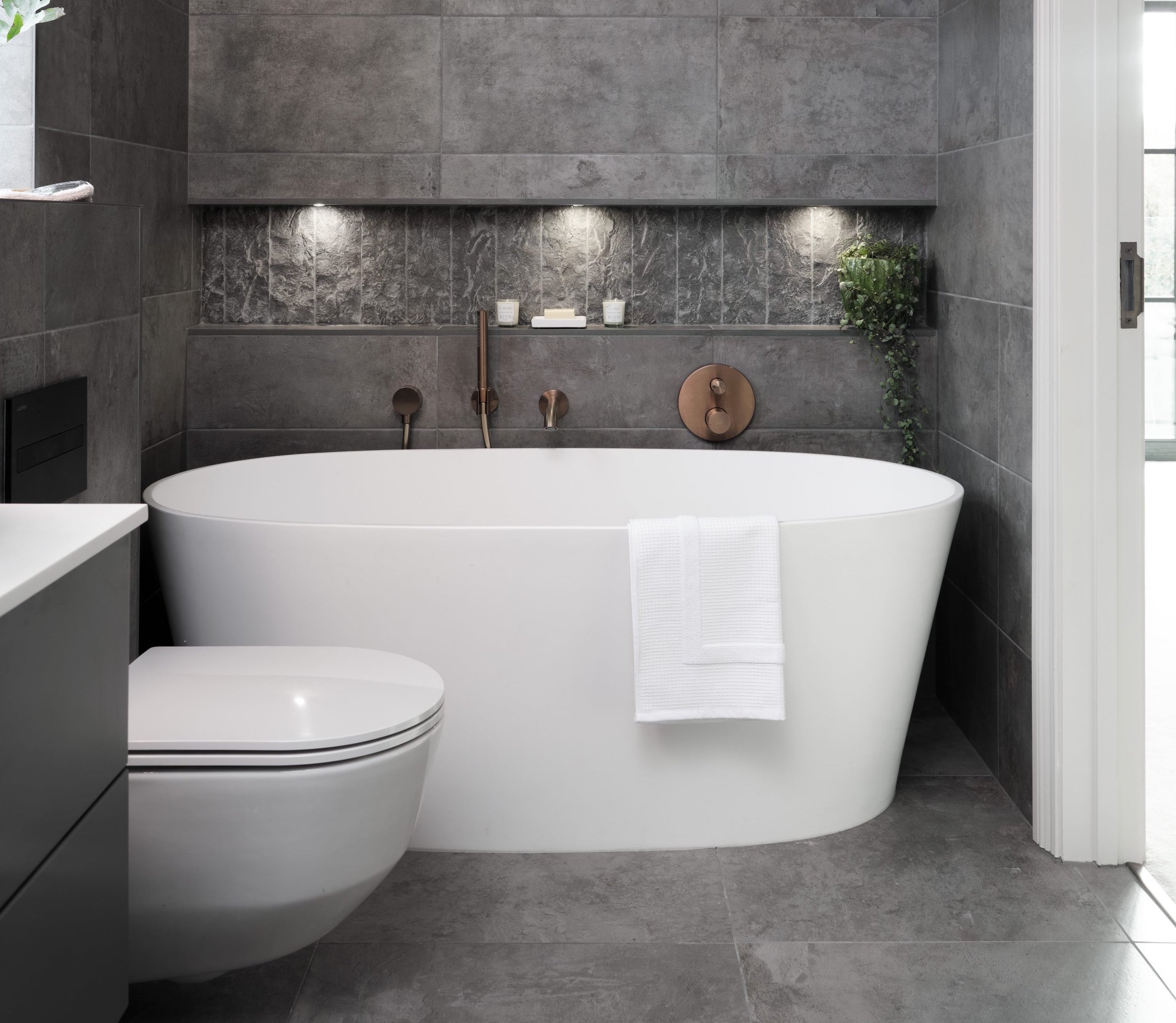 Freestanding Bathtub with Copper Hardware and Textured Niche