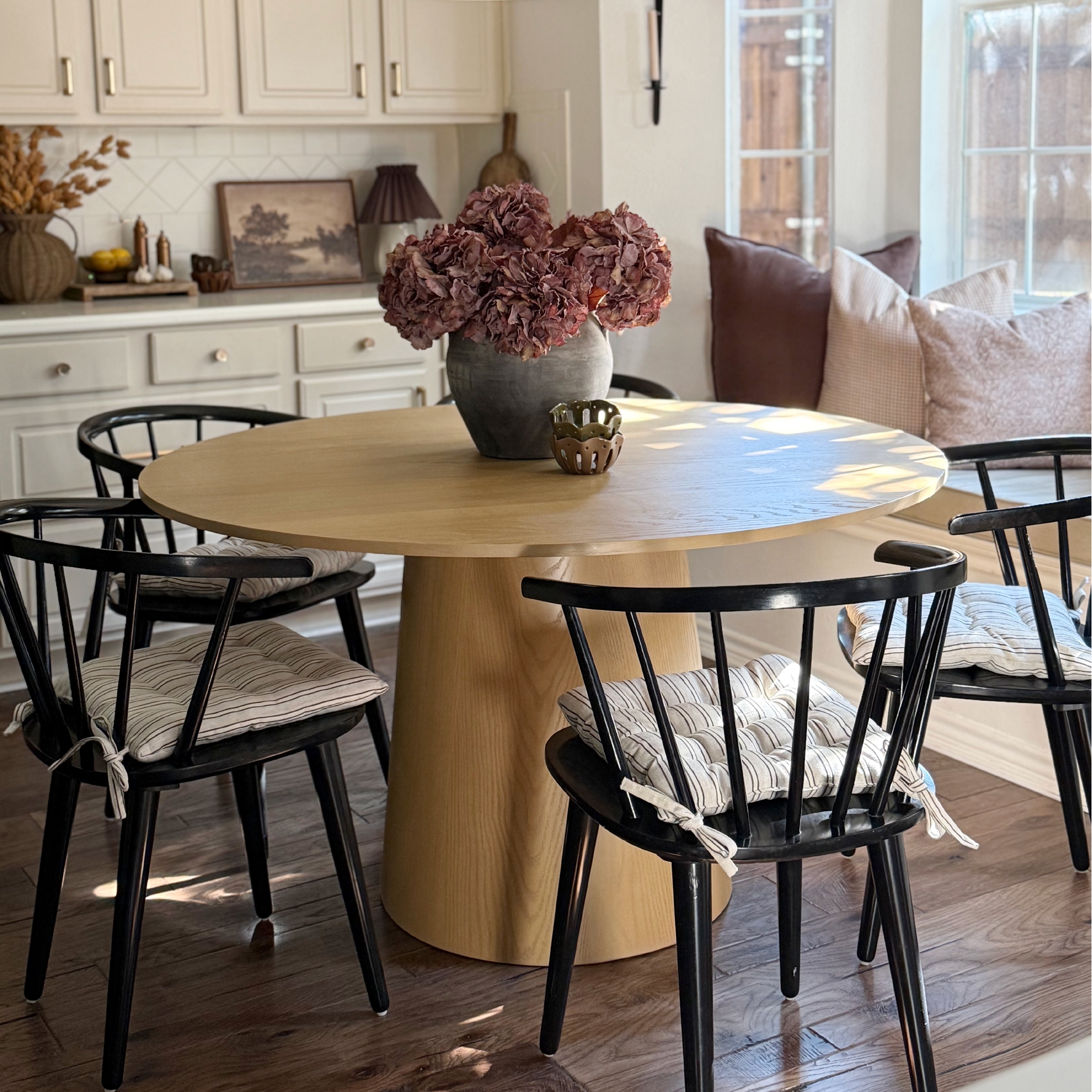 Round Pedestal Table: Conical base with matte black spindles
