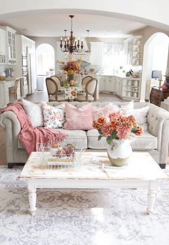 Tufted Sofa featuring Distressed Coffee Table and Blush Accents