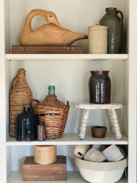 Decorative Shelf Display with Wicker Wrapped Bottles Styling