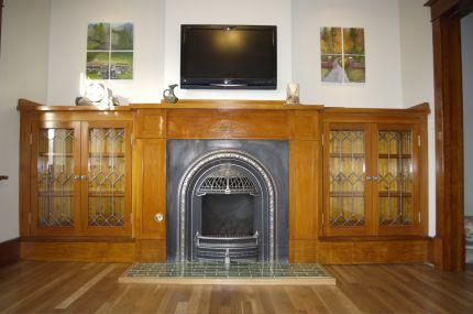 Fireplace Mantel with Leaded Glass Cabinets and Arched Metal Insert