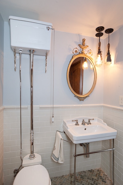 High Tank Toilet displays Exposed Chrome Piping for Subway Tile Bath