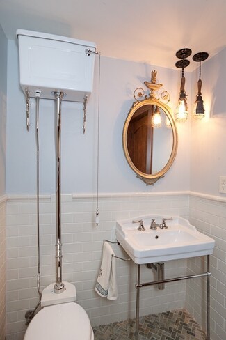 High Tank Toilet displays Exposed Chrome Piping for Subway Tile Bath