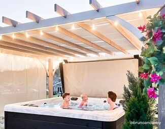 Hot Tub with Marbled Shell and String Lights Pergola Cover