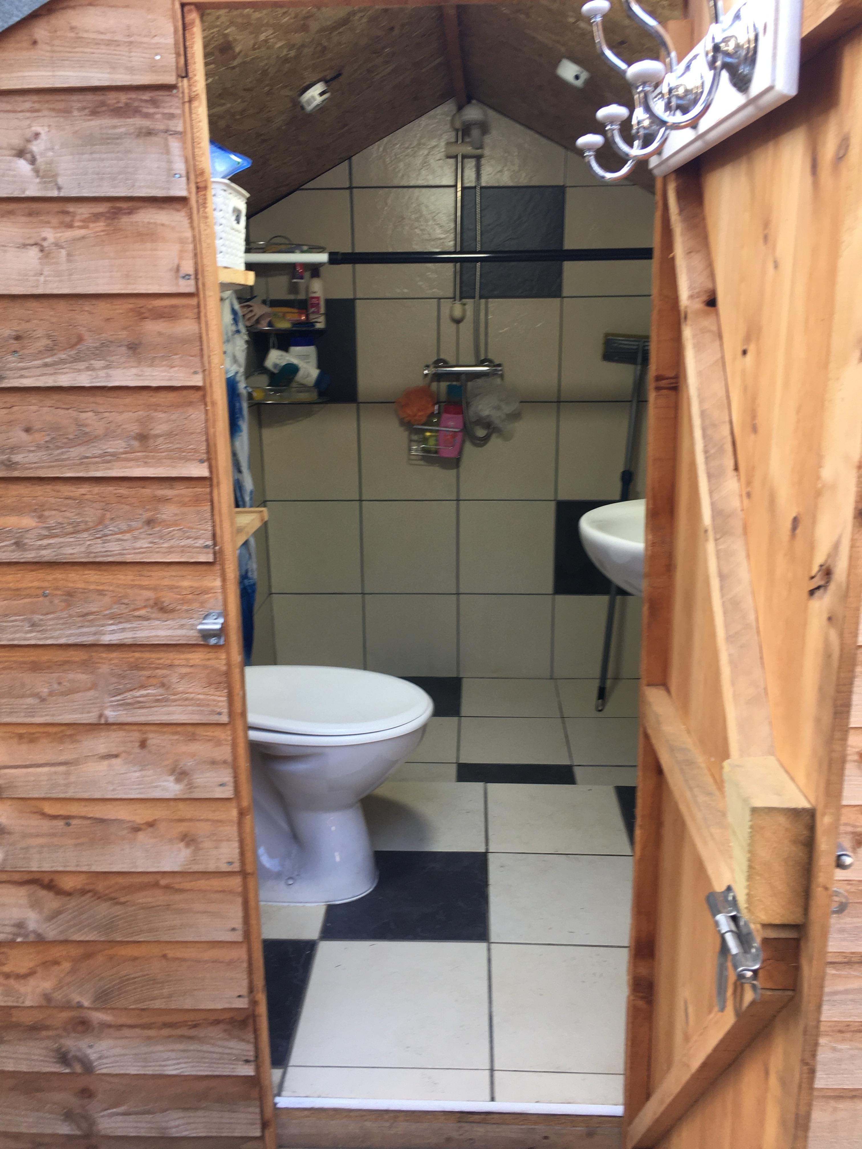 Outdoor Bathroom with Checkerboard Tile and Shower Unit