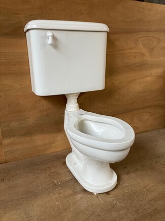 Toilet has Elongated Bowl and Antique White Finish Wall Mounted Tank