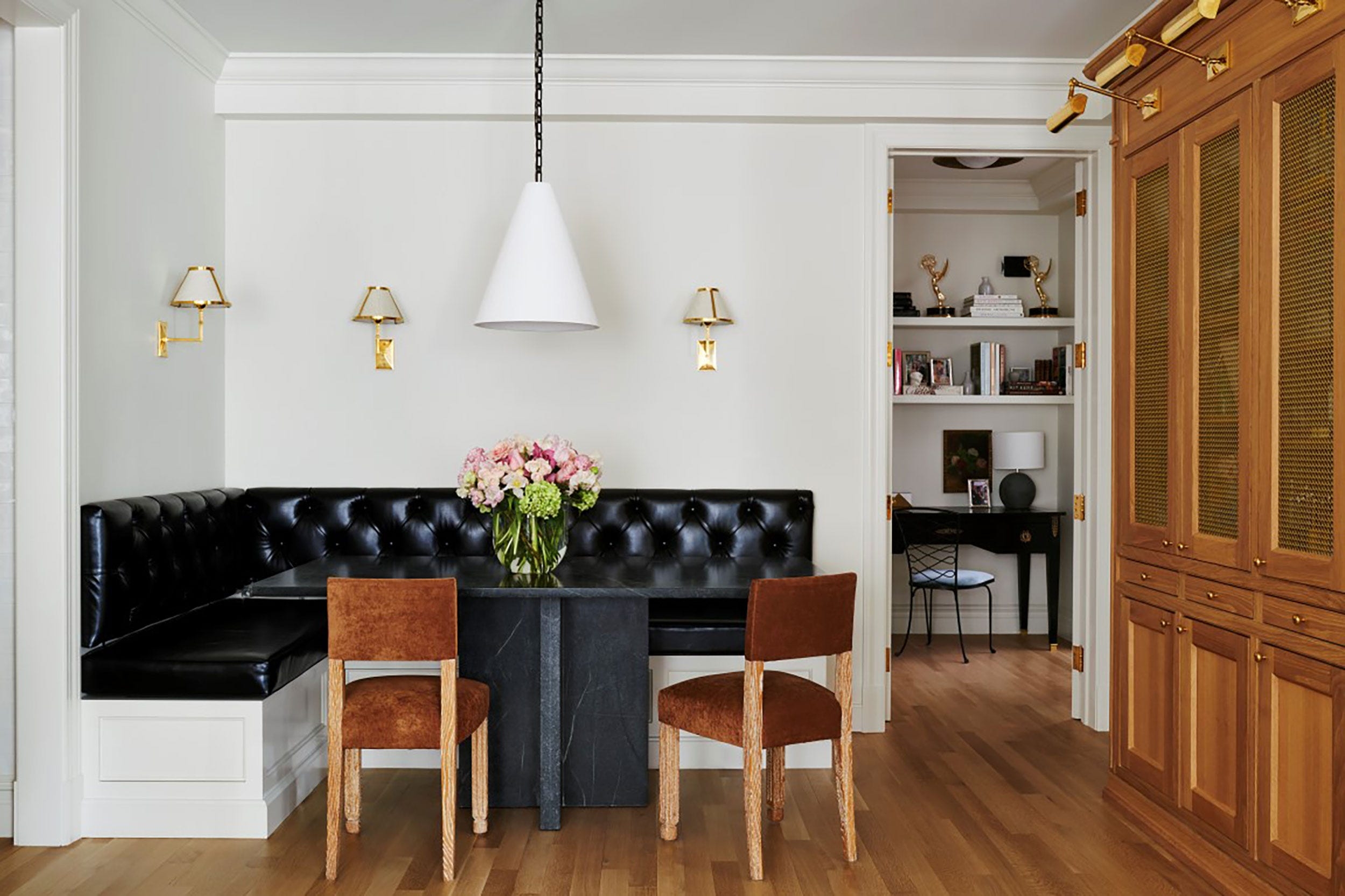 Tufted Banquette in Charcoal Black with Stone Top Table and Brass Sconces