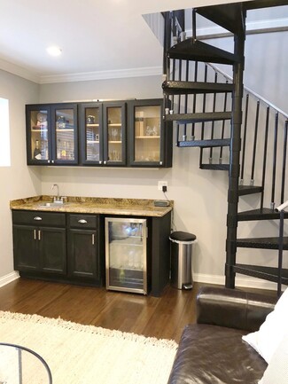 Wet Bar with Spiral Staircase and Glass Front Cabinets
