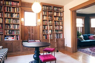 Built In Bookcase with Rolling Ladder and Magenta Tufted Stools