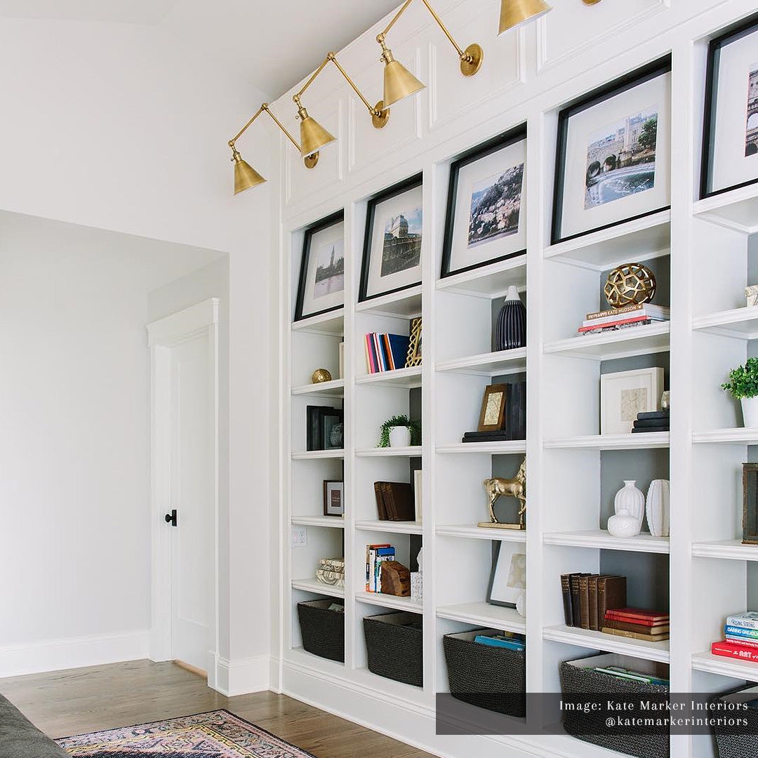 Built In Bookshelf with White Millwork and Double Arm Brass Sconces