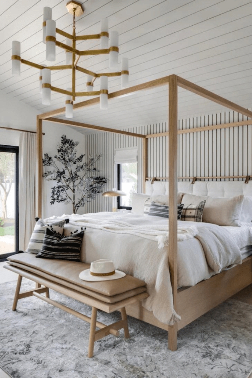 Canopy Bed with Brass Tiered Chandelier and Vertical Stripe Decor