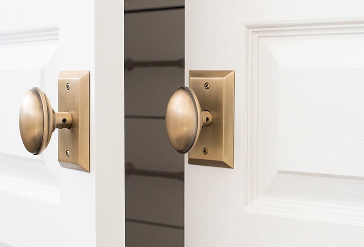 Door Hardware with Oval Knobs and Beveled Antique Brass Finish Plates