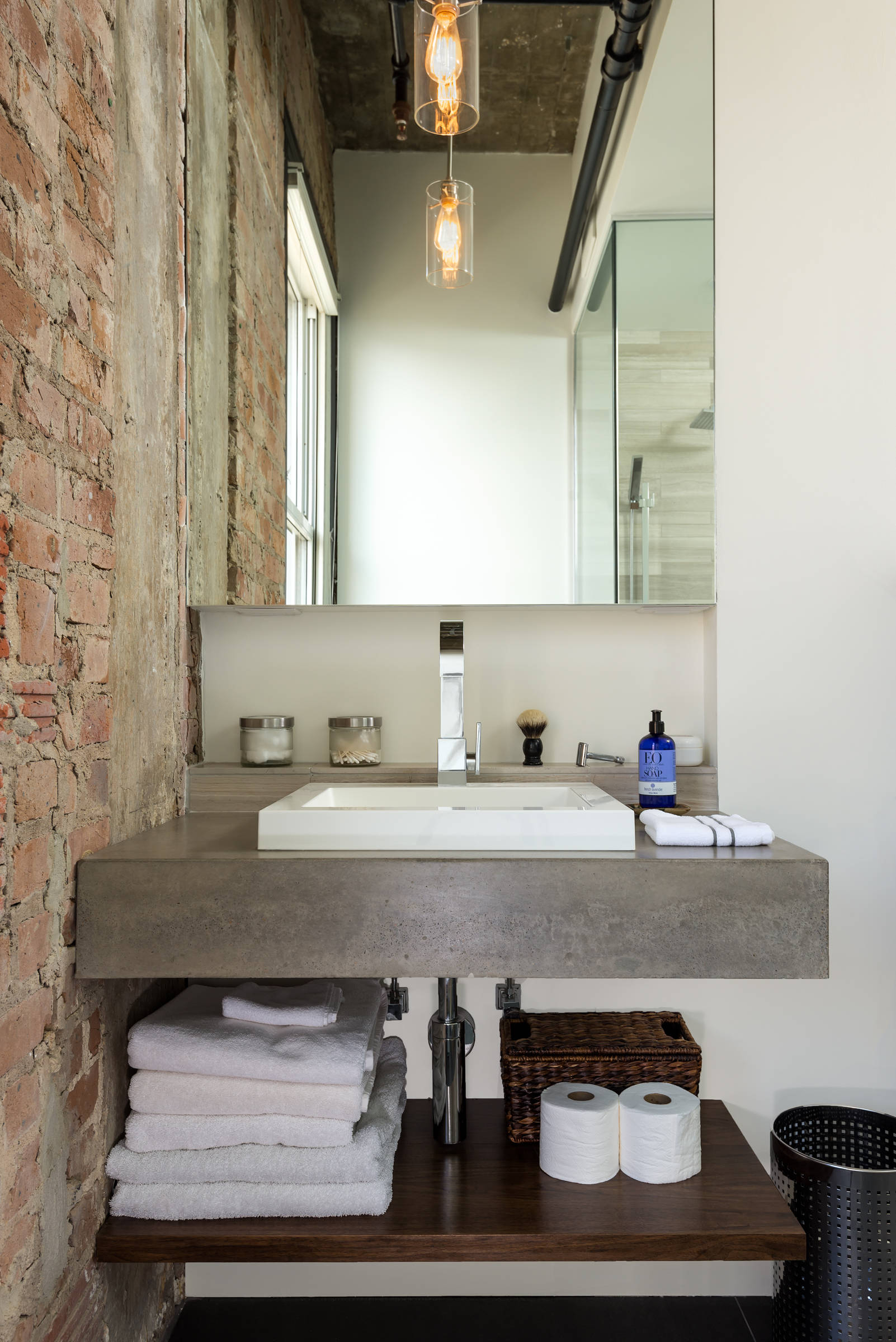 Floating Vanity with Concrete Top and Exposed Brick