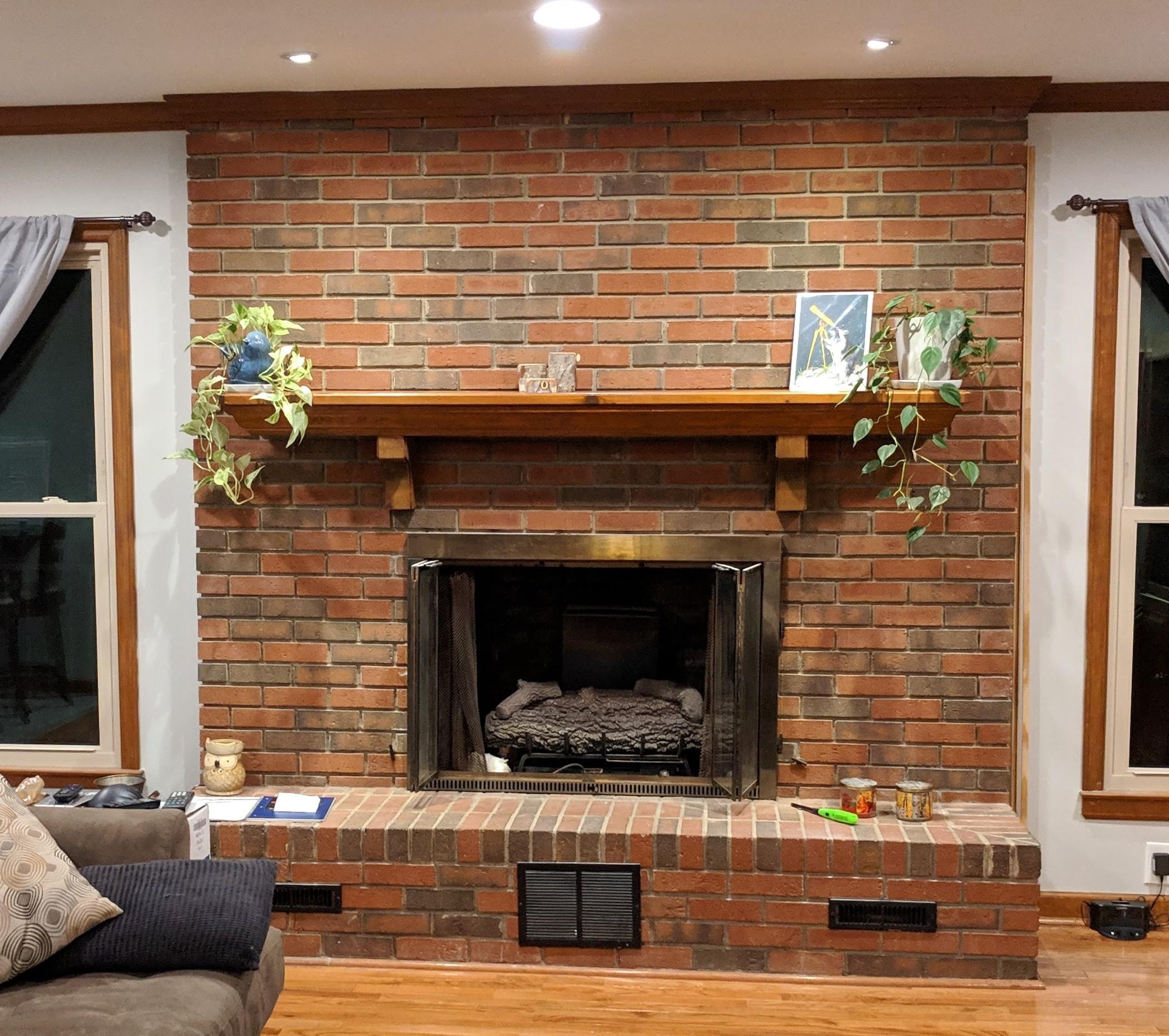 Brick Fireplace Featuring Wood Corbel Mantle and Raised Hearth