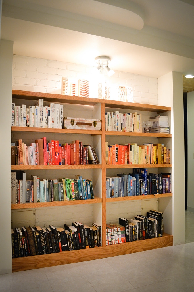 Built-In Bookshelves: Honey Wood with White Brick Back Panel