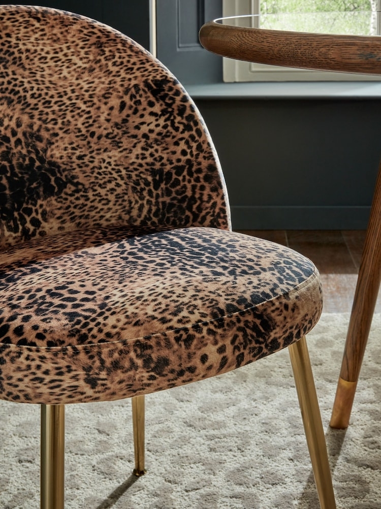Dining Chair including Gold Finished Legs and Curved Silhouette