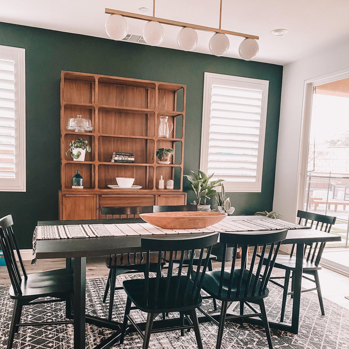 Dining Table: Black Live Edge Wood against Forest Green Wall